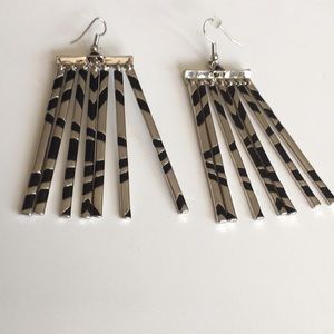 Chrome silver and black geometric design tassel earrings.